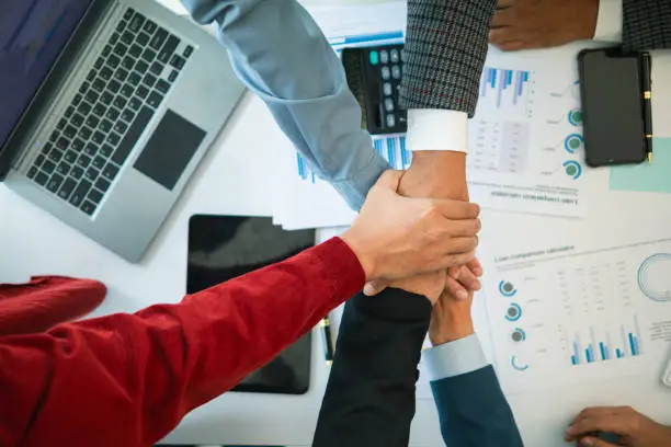 Photo of Businessmen and investors join hands symbolize friendship and cooperation in business success. concepts of group of businessmen and investors joining hands symbolize cooperation in doing business.