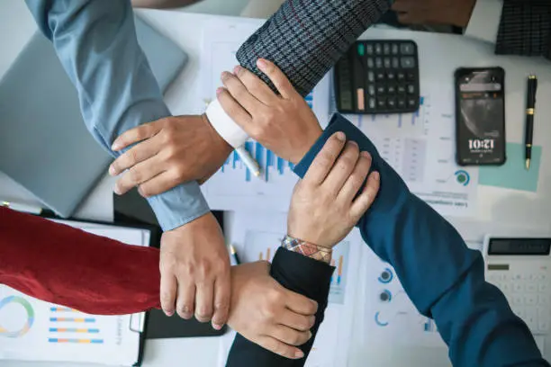 Photo of Businessmen and investors join hands symbolize friendship and cooperation in business success. concepts of group of businessmen and investors joining hands symbolize cooperation in doing business.