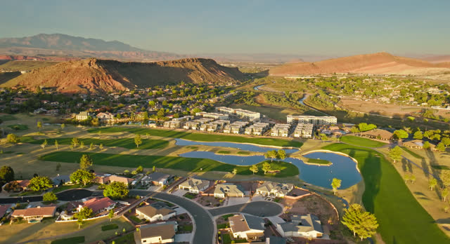 Backwards Drone Flight Over Suburban Houses Built Around Golf Course in St. George, Utah at Sunset