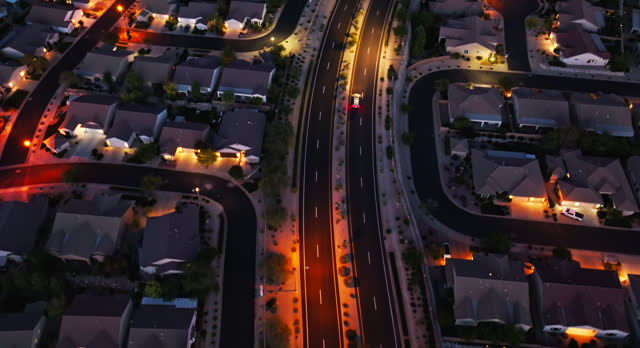 Car Driving on Road Through Suburban Housing Development in St. George, UT at Night - High Angle Drone Shot