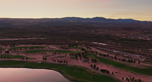Lush Green Golf Course in Arid Utah Landscape at Dusk - Aerial