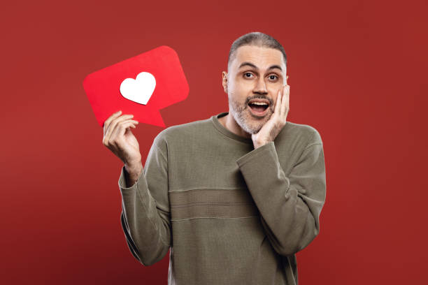 istock Man holding a paper speech bubble with a heart inside 1806195897