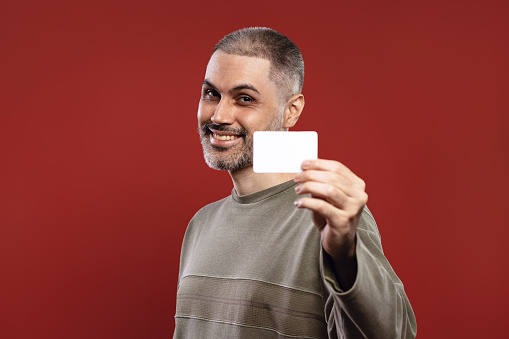 Smiling man holding a white card