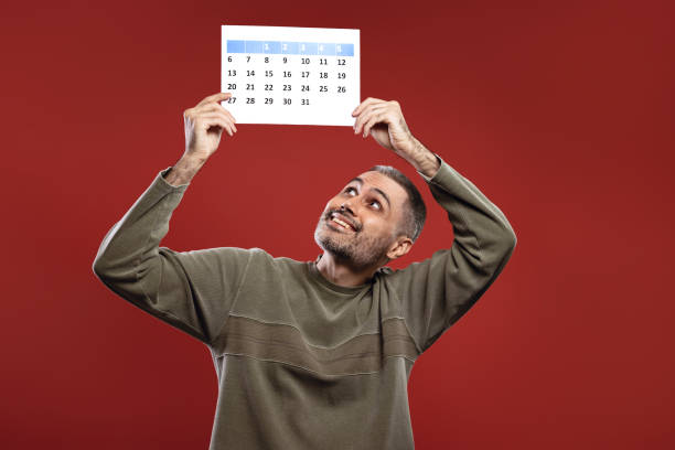 istock Man holding a paper calendar with both hands 1806197005