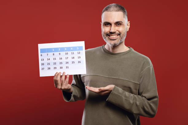 istock Smiling man holding a paper calendar 1806197008