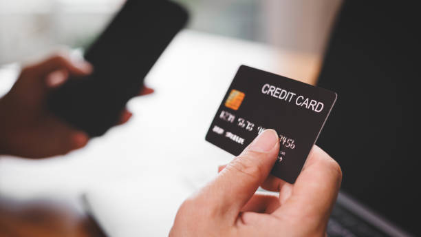 istock Man holding credit card and smartphone while perform payment 1806210636