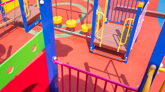 High angle view of modern colorful playground equipment on rubber floor in outdoors playground area