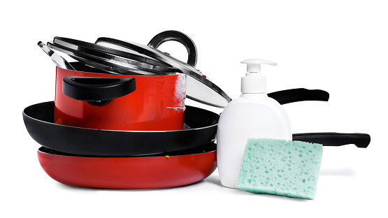 Stack of dirty kitchenware, dish detergent and sponge on white background