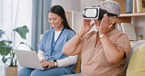 Senior woman, nurse and augmented reality glasses in home living room, sofa or laptop for smile in metaverse. Caregiver, doctor and elderly patient with vr vision, digital world or 3d user experience