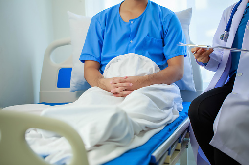 Doctor talking with patient in hospital, The doctor is explaining information about various diseases and treatment methods in detail for the patient to understand before treatment.