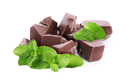 Milk chocolate chunks and mint leaves isolated on white