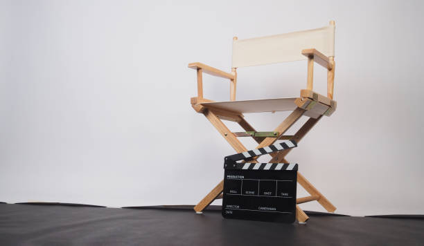 istock White director chair with clapper board on white background and black floor. 1806253017