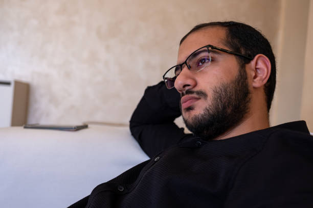 istock Portrait for bearded male sitting on sofa thinking and looking for future  while relaxing in home 1806264882