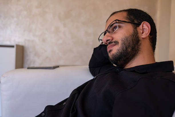 istock Portrait for bearded male sitting on sofa thinking and looking for future  while relaxing in home 1806264891