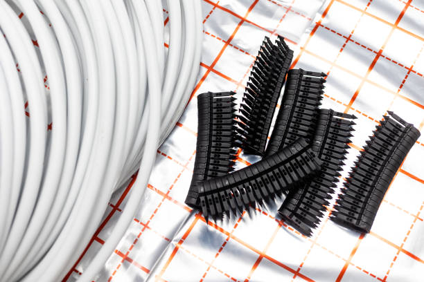 istock Equipment for installing underfloor heating, stapler with plastic buckles or fixation and coiled water pipes, concept of heated floor 1806279176