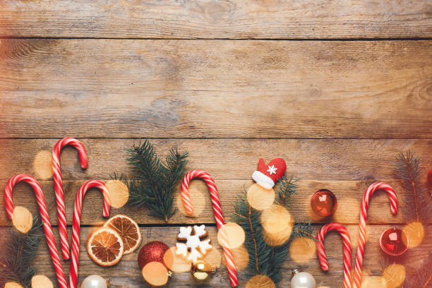 istock Beautiful Christmas composition with candy canes, fir tree branches and space for text on wooden table, flat lay. Bokeh effect 1806279695