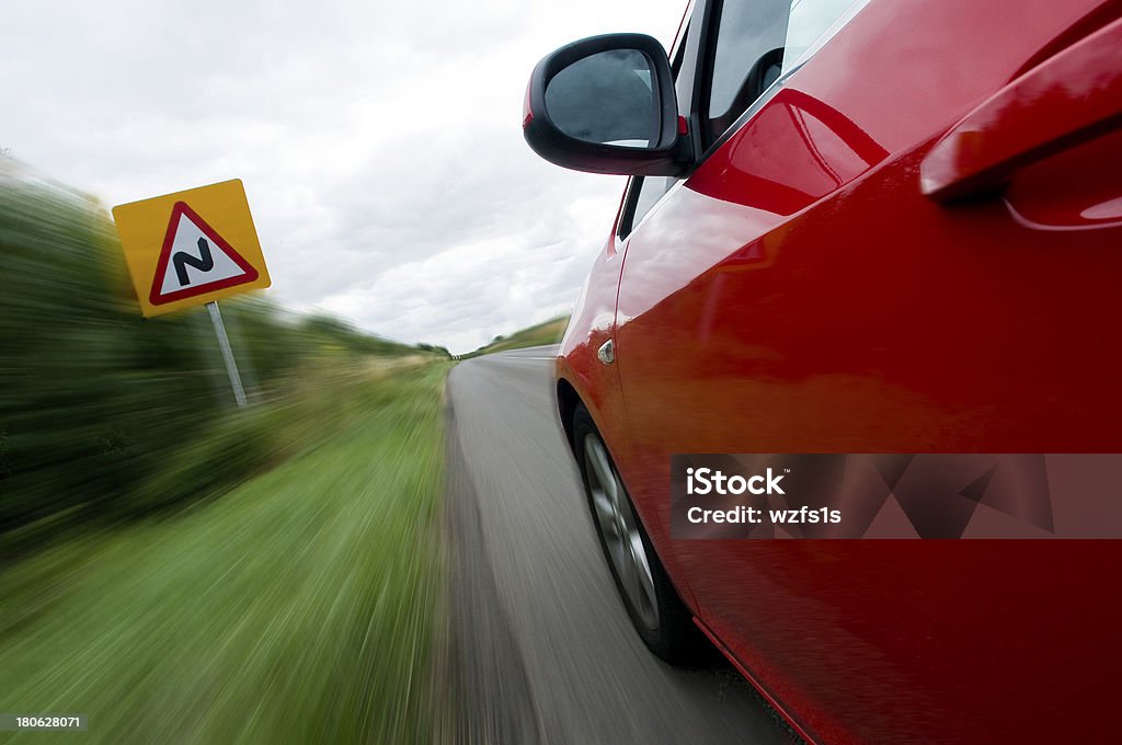 Slow, S bends Car traveling at speed past a sign indicating S bends in road Abstract Stock Photo