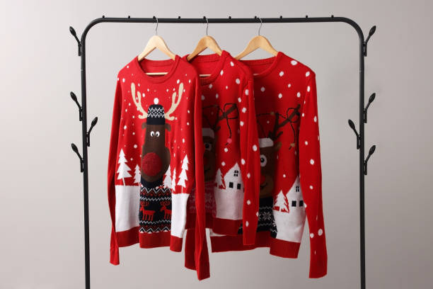 istock Different Christmas sweaters hanging on rack against light background 1806281369