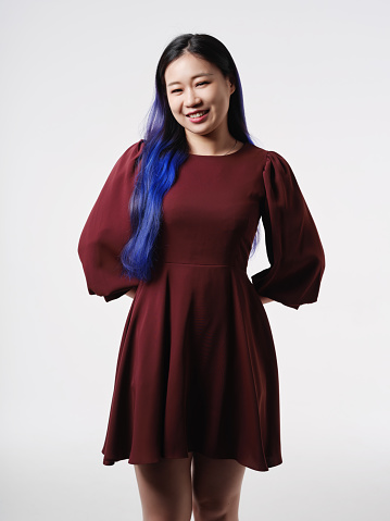 Beautiful Asian girl wearing dress in studio portrait, white background, long blue hair
