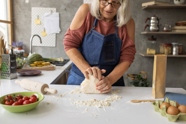 istock Old woman kneading dough 1806300787