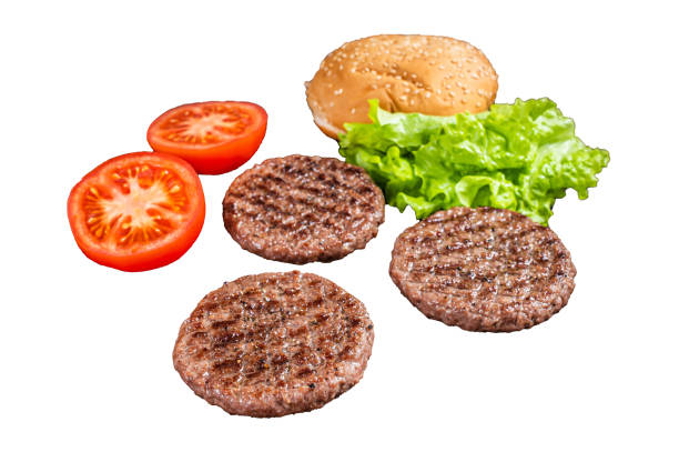 istock Grilled hamburger patties with tomatoes and seasonings on kitchen table.  Isolated, white background. 1806302419