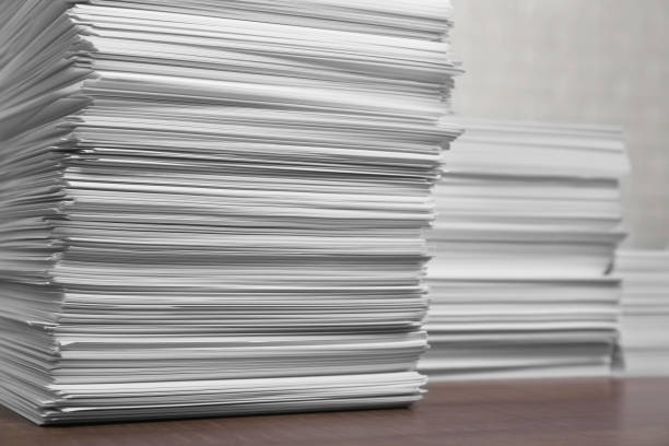 istock Stacks of white paper sheets on wooden table 1806306850