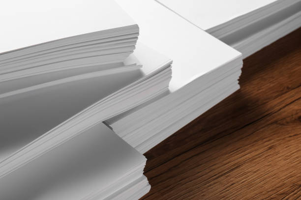 istock Stacks of white paper sheets on wooden table, closeup. Space for text 1806307389
