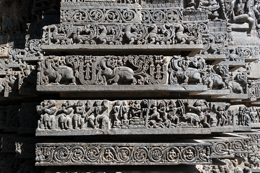 Beautiful stone carvings on the wall of the ancient Hoysaleshwara temple in Halebeedu in Karnataka.