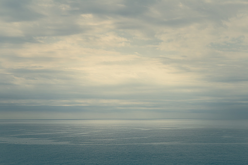 Calm and blue sea landscape. There are clouds in the sky and drawn currents can be seen in the water.