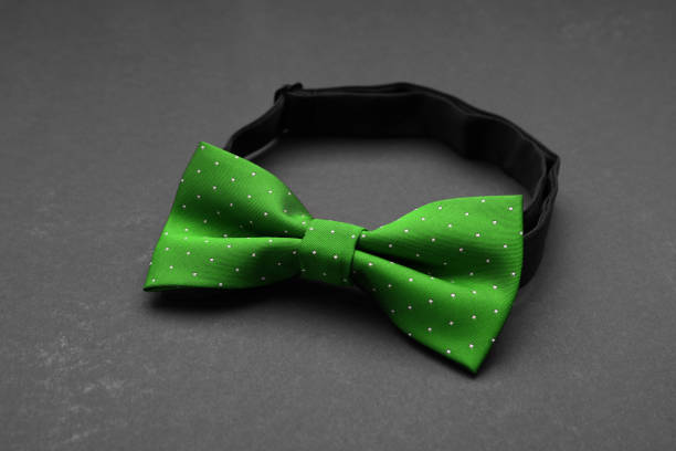 Stylish green bow tie on grey background, closeup