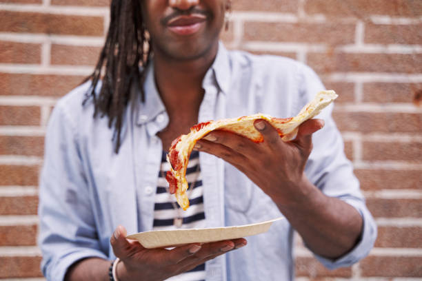 istock unrecognizable man holding a slice of pizza in his hand 1806320488