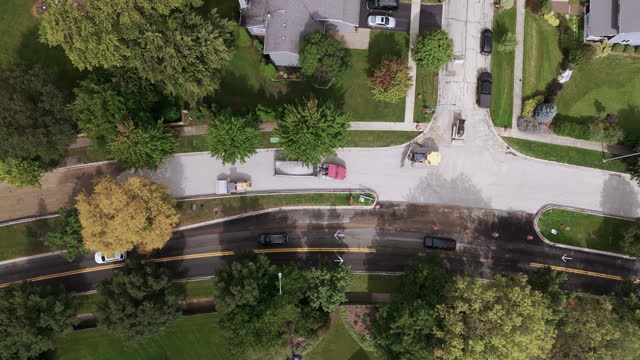 Aerial time lapse view over asphalt road construction in suburbs. Top down shot