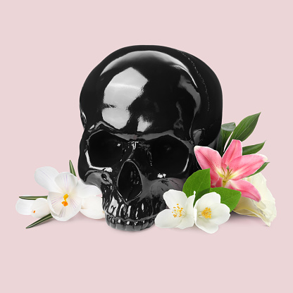 Black skull and beautiful flowers on beige background