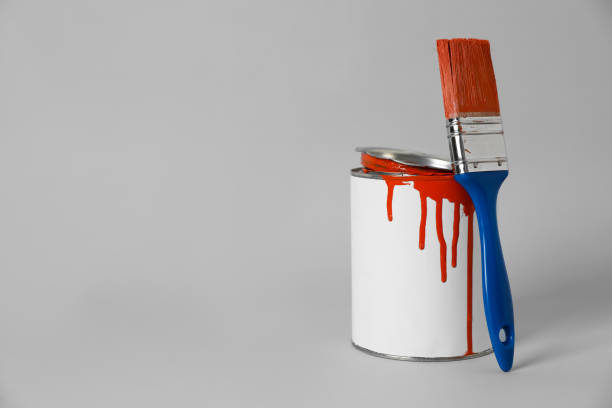 istock Can of orange paint and brush on grey background. Space for text 1806326329