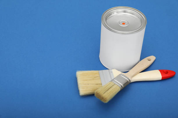 istock Can of orange paint and brushes on blue background. Space for text 1806326899
