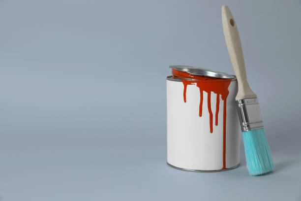 istock Can of orange paint and brush on grey background. Space for text 1806326912