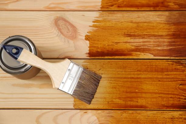 istock Brush and can with wood stain on wooden surface, top view. Space for text 1806329716