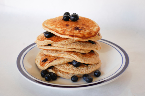 Healthy Blueberry Oat Pancakes on a white plate with a white background