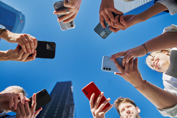 istock Group of business workers smiling happy and confident. Standing on a circle with smile on face using smartphone together at the office. 1806339086