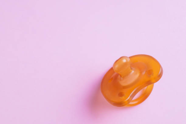 istock New baby pacifier on pink background, top view. Space for text 1806345676