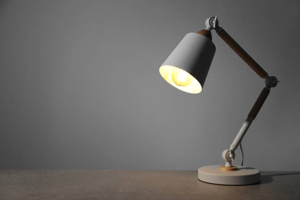 istock Stylish modern desk lamp on light gray table, space for text 1806359118