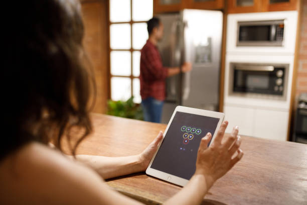 istock Woman using tablet app to change setting in her smart home 1806359130