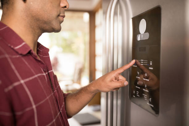 istock Man using the fridge's digital panel to cool groceries faster 1806359647
