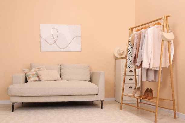 istock Stylish living room interior with comfortable sofa and clothing rack 1806360231