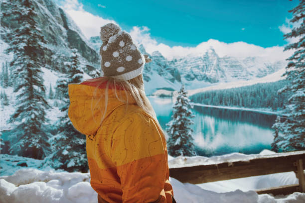 mujer disfrutando de la vista en la nieve en el lago de la montaña - travel destinations mountain hiking profile fotografías e imágenes de stock