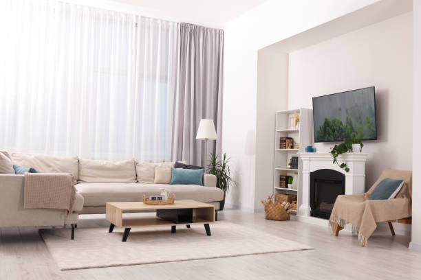 istock Stylish living room interior with cozy sofa, table, TV set and fireplace 1806361829