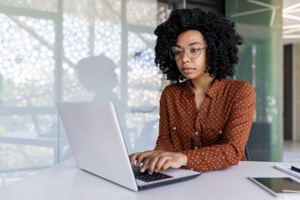istock Serious thinking woman working with laptop, typing on keyboard, thinking concentratedly about solving current problems, business woman successful satisfied and confident at workplace inside office 1806373686