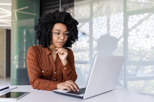 istock Serious thinking woman working with laptop, typing on keyboard, thinking concentratedly about solving current problems, business woman successful satisfied and confident at workplace inside office 1806373687