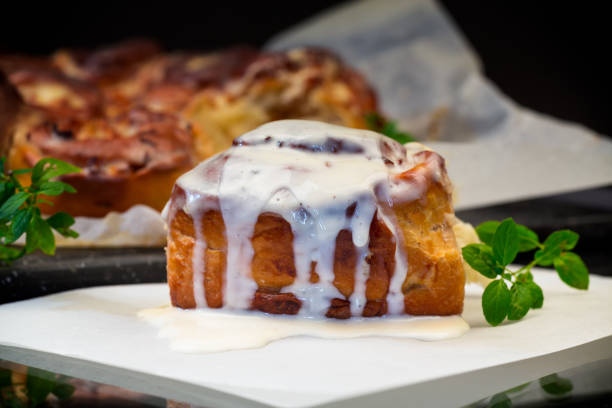 istock cooked baked sweet cinnabon with cream on black background 1806387311