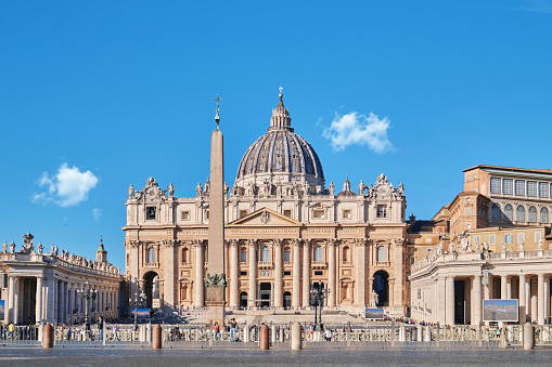 Beautiful view at Piazza Venezia with Italian flag, blue sky and sunny day with many tourists and sightseeing buses, Rome, Italy